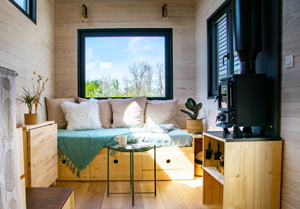 vue intérieure de la tiny house la Odette avec salon équipé et poêle à bois