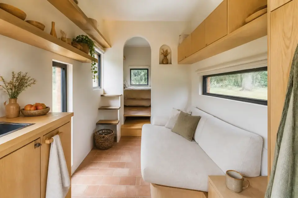 Intérieur compact d’une micromaison aménagée avec du mobilier simple et lumineux