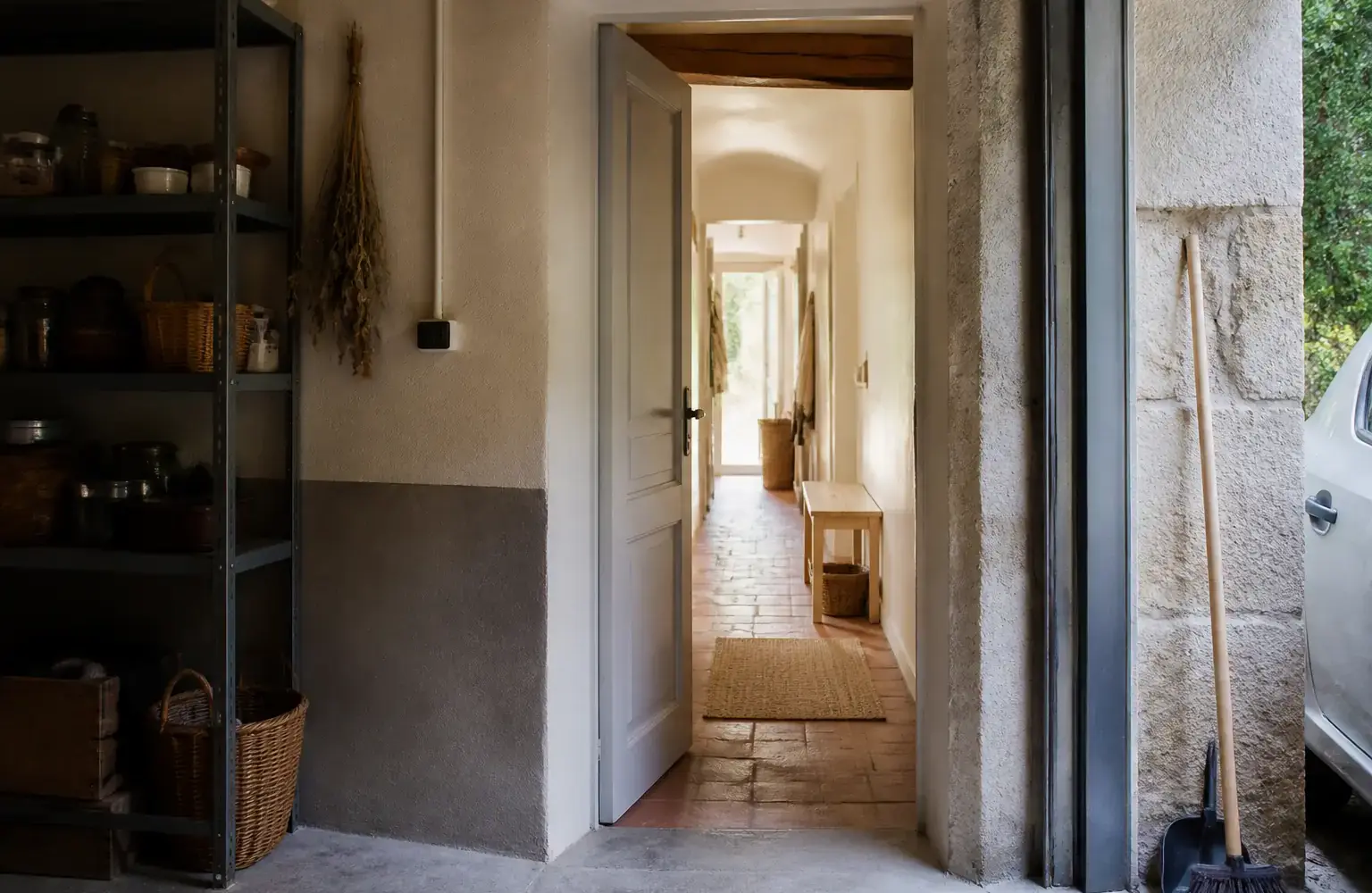 Porte de service entre un garage et un couloir de maison, vue de face, lumière naturelle