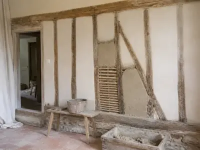 Mur en pan de bois dont le remplissage en torchis est visible, en cours de réparation