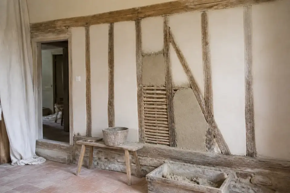 Mur en pan de bois dont le remplissage en torchis est visible, en cours de réparation